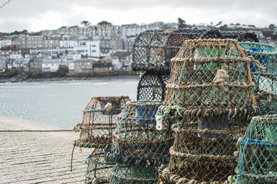 Stack of fishing net on sea against buildings