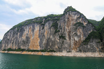 Rock formations by sea against sky