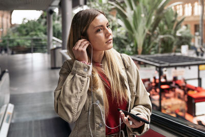 Woman listening music while standing outdoors