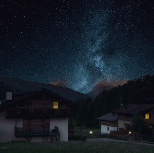 House on illuminated mountain against sky at night
