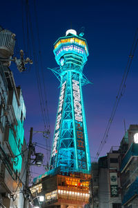 Low angle view of illuminated buildings against blue sky