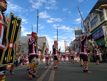 People on street in city against sky