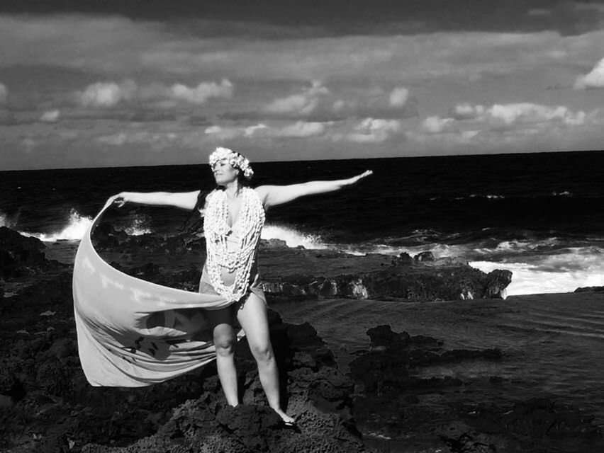 WOMAN STANDING IN FRONT OF SEA