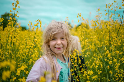 Portrait of smiling girl standing on field