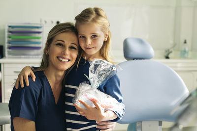 Portrait of smiling dentist and patient in medical clinic