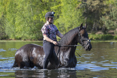 Woman riding horse in river