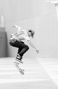 Young man performing stunt with skateboard at park