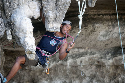 Full length of man hanging on rock