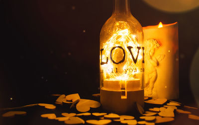Close-up of illuminated tea light candles on table