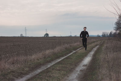 Rear view of people walking on field