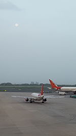 Airplane on runway against sky