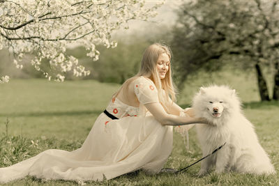 Side view of woman with dog on field