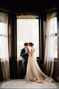 Young couple standing near window