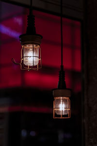 Low angle view of illuminated light bulb hanging from ceiling