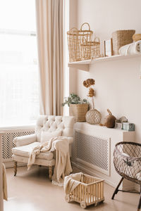 Young parents ' bedroom in beige shades. a feeding chair, a cradle and a scandinavian-style decor