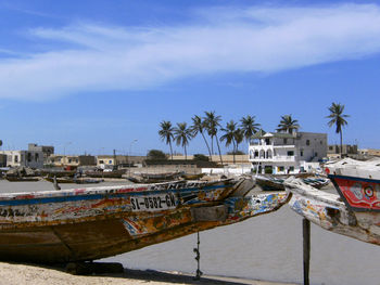 Boats moored at harbor against sky