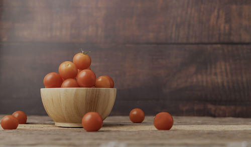 Group tomato in a wood bowl place on the wooden table. cherry tomatoes it is a small tomato