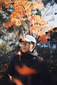 Low section of woman with autumn leaves