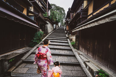 Rear view of people walking on staircase