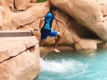 Boy jumping into swimming pool