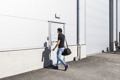 Full length of young man entering warehouse