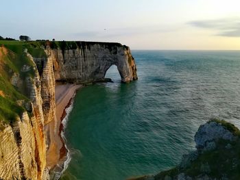 Scenic view of rock formation in sea against sky