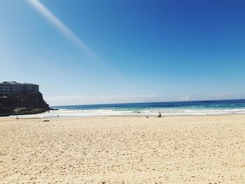 Scenic view of beach against clear blue sky