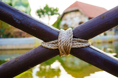 Close-up of rope tied to wooden fence