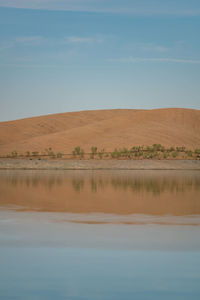 Desert like hill landscape with reflection on the water on a dam lake reservoir in terena, portugal