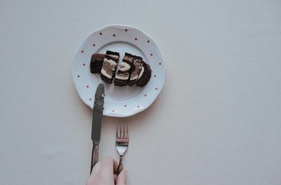 Directly above shot of hand holding ice cream in plate