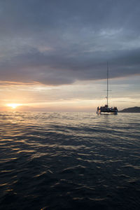 Scenic view of sea against cloudy sky at sunset