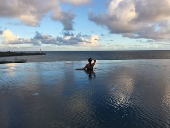 Man in sea against sky