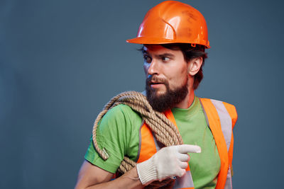 Man working against orange background