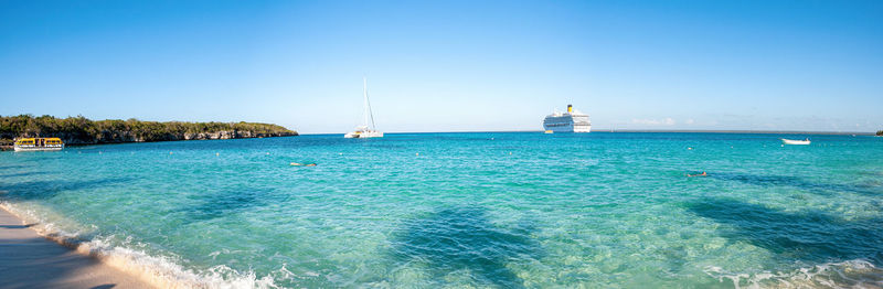 Sailboats sailing in sea against clear blue sky