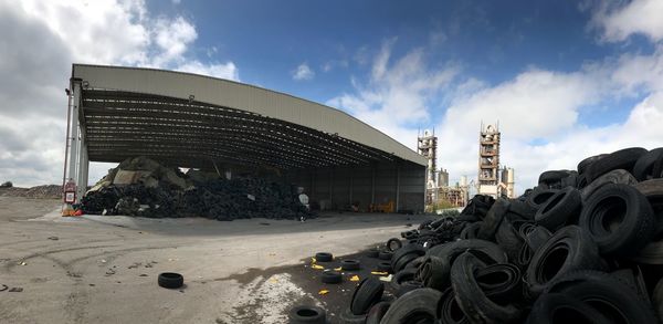 Panoramic view of abandoned cars against sky in city