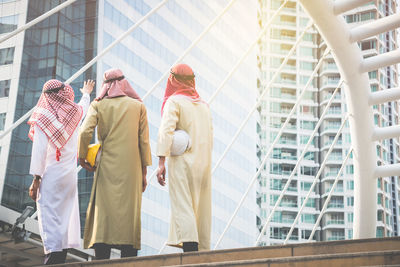 Rear view of architects standing against buildings