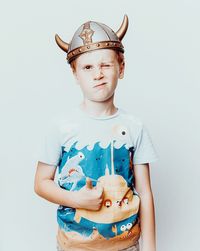 Portrait of boy standing against white background