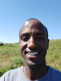 Portrait of smiling man against clear blue sky