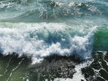 High angle view of waves splashing on sea