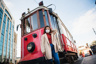 Low angle portrait of red man against sky