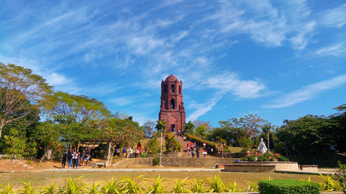 Low angle view of people in church against cloudy sky