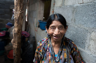 Portrait of smiling woman against wall