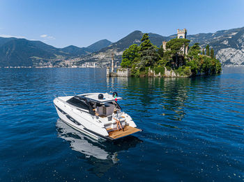 Boat sailing in sea against blue sky