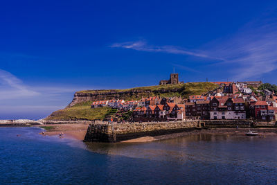 Building by sea against blue sky