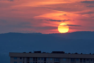 Silhouette buildings against sky during sunset