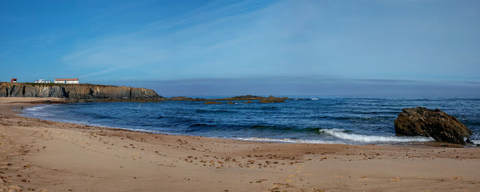 Scenic view of beach against blue sky