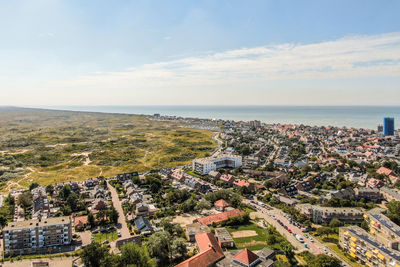 High angle view of townscape by sea against sky