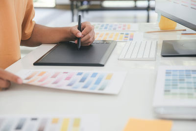 Midsection of man using laptop on table