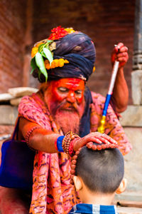 Portrait of man holding multi colored umbrella