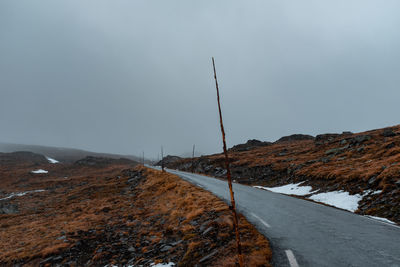 Road by mountain against sky